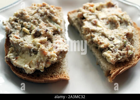 Carni macinate di aringhe su una fetta di pane nero su sfondo bianco vicino. Selective soft focus. Copia di testo spazio. La tradizione holyday concept Foto Stock