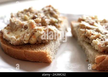 Carni macinate di aringhe su una fetta di pane nero su sfondo bianco vicino. Selective soft focus. Copia di testo spazio. La tradizione holyday concept Foto Stock