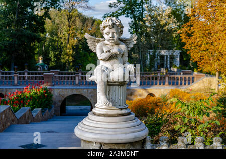 Fienile statua di un angelo in un parco d'autunno in un caldo pomeriggio contro uno sfondo di foglie di giallo, close-up Foto Stock