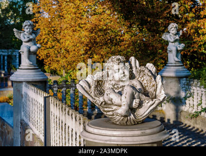 Fienile statua di un angelo in un parco d'autunno in un caldo pomeriggio contro uno sfondo di foglie di giallo, close-up Foto Stock