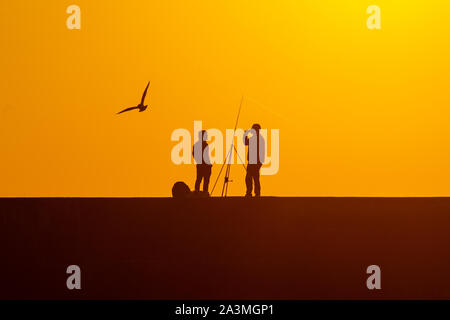 La pesca al tramonto sul molo Aberystwyth Foto Stock