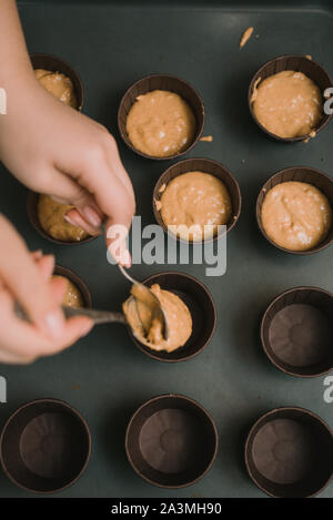 Il panettiere crea i tortini in stampi. Il panettiere crea muffin alla carota. Foto Stock