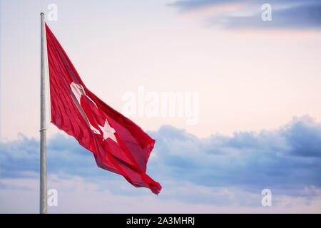 Bandiera della Turchia fluttuante al di sopra di un nuvoloso cielo di sera. Foto Stock