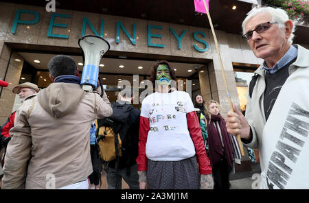 I manifestanti si raccolgono al di fuori Penneys su O'Connell street a Dublino durante una ribellione di estinzione (XR) dimostrazione, come i rivenditori di moda sono venuti sotto intenso scrutinio nell ultimo anno da attivisti ambientali. Foto Stock