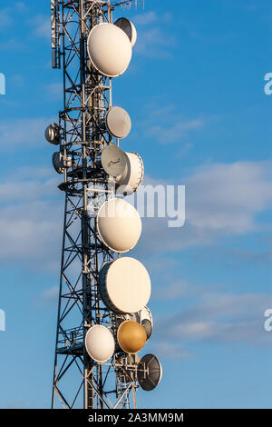 Telecommunications Tower, antenna e parabola satellitare con cielo blu su sfondo. Foto Stock