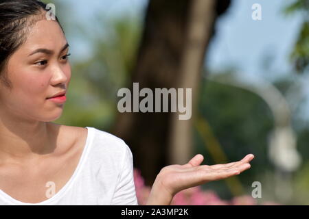 Un indeciso giovane persona asiatica Foto Stock