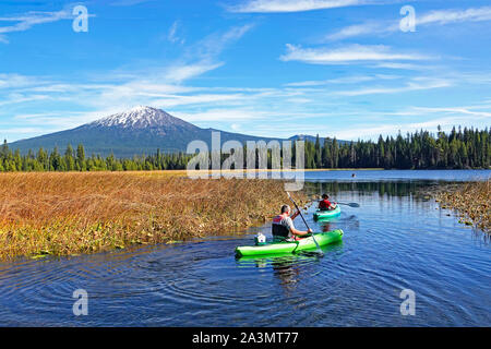 Kayakers sul lago Hosmer in Oregon Cascade Mountains all'inizio dell'autunno. Mount Bachelor è in background. Foto Stock