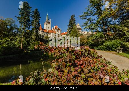 Pruhonice, Repubblica Ceca - 7 Ottobre 2019: vista panoramica del famoso castello romantico in piedi su una collina nel parco con alti alberi di verde. Soleggiata giornata autunnale. Foto Stock