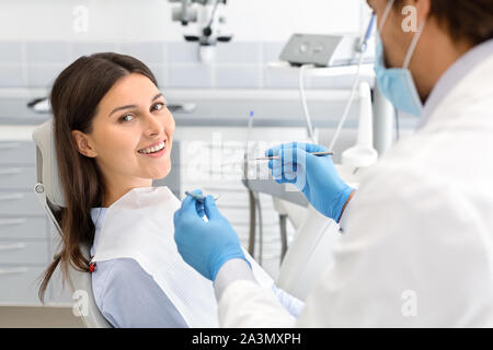 Donna felice facendo controllare fino in clinica dentale Foto Stock