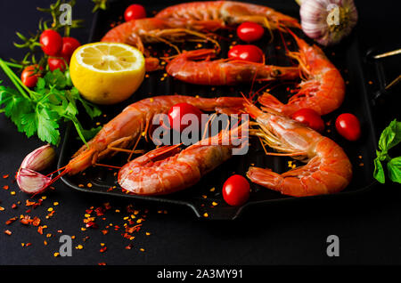 Fresco gamberoni tigre sul ferro padella per grigliare e ingredienti pronti per la cottura. Cucina Italiana concetto. Foto Stock