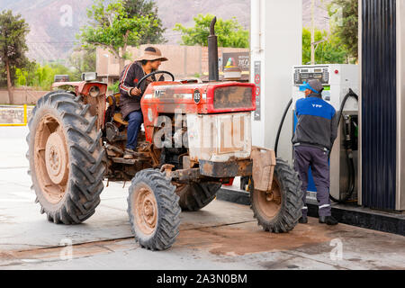 Un trattore agricolo ricariche con gasolio a un YPF stazione di riempimento in Tilcara, Argentina del nord. Foto Stock