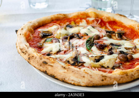 Close up tradizionale pizza capricciosa in un ristorante italiano. Vista frontale. Il cibo italiano concept Foto Stock