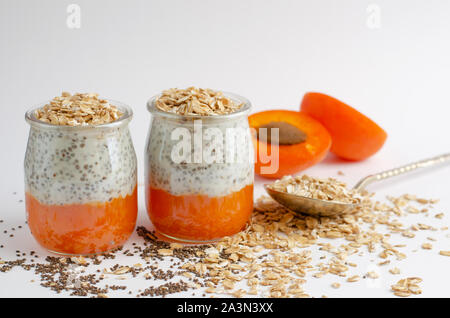 Semi di Chia budini con fresche Albicocche e oat pasti su bianco con uno spazio per il testo. Pulire mangiare, dieta food concept Foto Stock