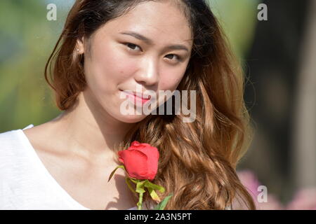 Impassibile femmina adulta con un fiore Foto Stock