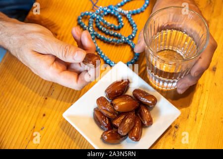 Immagine simbolo rompendo il veloce nel mese di Ramadan, per i musulmani, acqua e date dopo il tramonto, come il primo pasto della giornata, Foto Stock