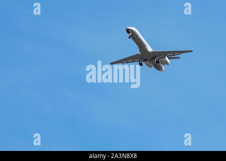 Vista dal basso dell'aeroplano Embraer ERJ-145 con equipaggiamento di atterraggio fuori mentre si avvicina all'aeroporto per l'atterraggio Foto Stock