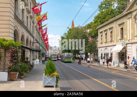 Rue de la Corraterie a Ginevra, Genève, Svizzera con bandiere e mezzi pubblici Foto Stock