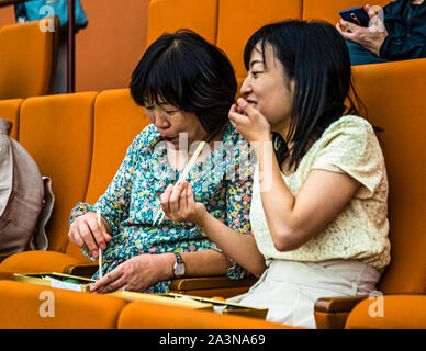 Gli spettatori mangiano nell'auditorium durante la pausa del Teatro Kabuki di Tokyo Foto Stock