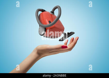 Mano femmina con red aspirapolvere su sfondo blu Foto Stock