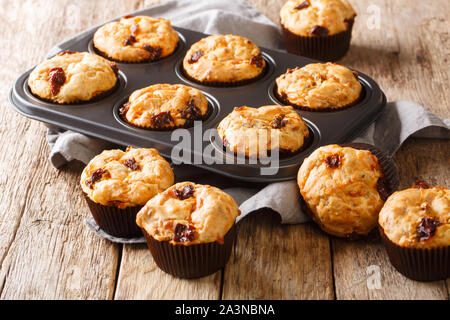 Luce muffin vegetariano con pomodori secchi close-up in una teglia sul tavolo orizzontale. Foto Stock