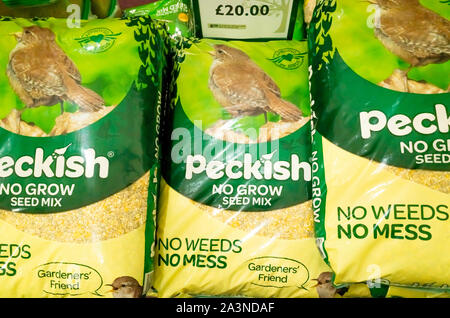 Una pila di sacchi di grandi dimensioni di un certo languorino. marchio di uccelli selvatici cibo per la vendita in un garden center in North Yorkshire, Inghilterra Foto Stock