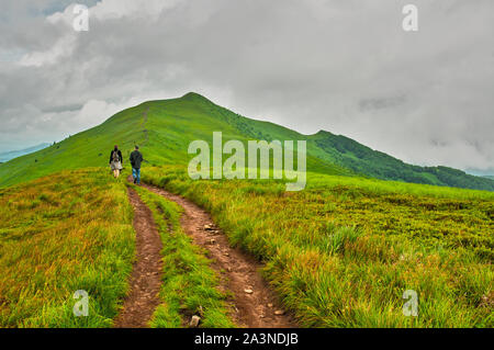 Due turisti sul sentiero vagare verso il picco di montagna Foto Stock