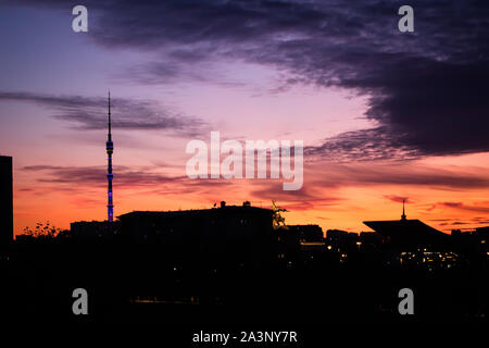 Silhouette di edifici di Mosca al tramonto con una statua di un lavoratore e un collettivo di agricoltore e Kuskovo torre a VDNH, Mosca. Foto Stock