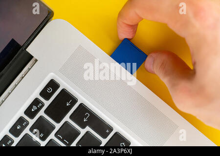 Mano azienda Flash SD card drive e inserirlo nel computer portatili Foto Stock