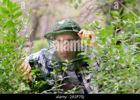 Un viaggiatore l uomo nella maschera di zanzara per proteggere il viso da insetti Foto Stock