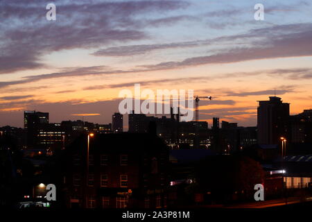 Sunrise oltre lo skyline di Leeds Foto Stock