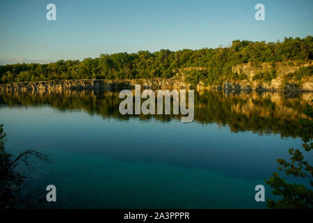 Una vista delle scogliere calcaree riflessa nel vetro come il lago af la cava a Francia Park West di logansport in Cass county Indiana Foto Stock