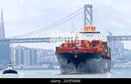 Oakland, CA - Luglio 08, 2019: rimorchiatori assistere nave cargo TOKYO EXPRESS di manovra attraverso la baia di San Francisco al Porto di Oakland, il quinto b Foto Stock