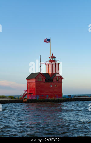 Grande faro rosso come il sole sorge su una bella mattina di autunno. Holland, Michigan, Stati Uniti d'America Foto Stock