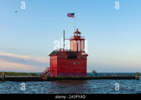 Grande faro rosso come il sole sorge su una bella mattina di autunno. Holland, Michigan, Stati Uniti d'America Foto Stock