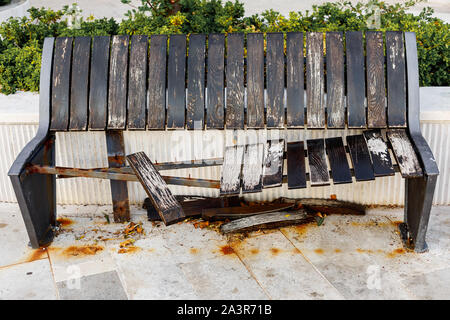 Danneggiato e rotture di legno marrone panca sulla strada, invecchiamento o atti di vandalismo concept Foto Stock