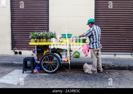 Venditore ambulante di vendita frutta fresca su un marciapiede in città murata di Cartagena Foto Stock