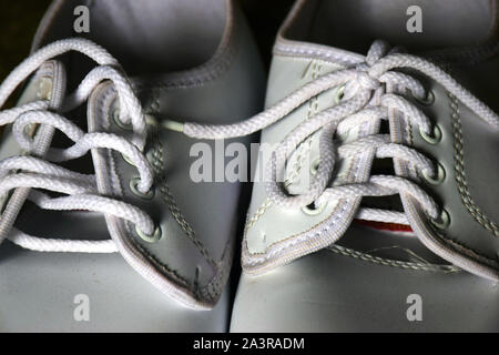 Close up e messa a fuoco selettiva sneakers bianco su pavimenti in legno, basso concetto chiave, bianco scarpe. Foto Stock