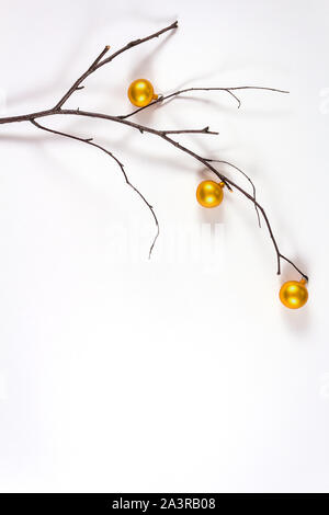 Nuovo anno la natura la minima nozione. Il ramo decorate con piccoli natale palline dorate. Foto Stock