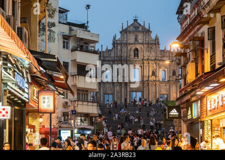 Macao, Cina - 15 Ottobre 2018: turisti stolling attorno le strette strade di Macao città vecchia con il famoso rovinato la facciata della cattedrale di St Paul in th Foto Stock