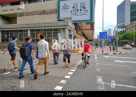 Pedoni e ciclisti attraversando Upper Cross Street a Chinatown, Singapore, sui loro percorsi designati rispettivamente Foto Stock