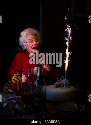 Signora anziana sorpreso da sparkler sul compleanno Foto Stock