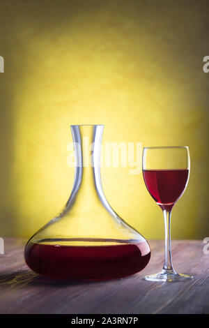 Decanter con vino rosso e vetro su sfondo in stucco con tracciato di ritaglio Foto Stock
