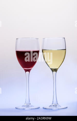 Il vino rosso di vetro e vino bianco vetro isolato su una luce di sfondo blu Foto Stock