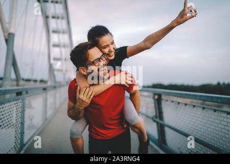 La mattina presto allenamento. Coppia felice in esecuzione attraverso il ponte Foto Stock