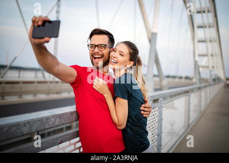 Sport l uomo e la donna che fa selfies. Coppia felice costeggiata e in posa per la fotocamera Foto Stock