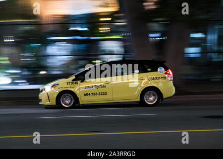 VANCOUVER, BC, Canada - Settembre 21, 2019: a Vancouver Yellow taxi accelerando verso West Georgia Street su un occupato Sabato notte. Foto Stock