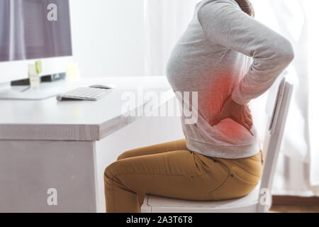 Dolore ai reni. Dolore alla schiena di una donna dal lavoro al computer. Foto Stock