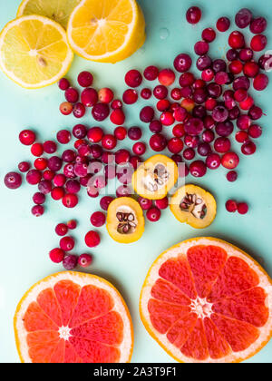 Piatto trendy laici seamless pattern affettati misti agrumi come sfondo con diverse bacche, concetto di mangiare sano, dieta, dall'alto verso il basso Foto Stock