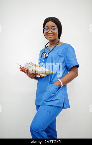 Ritratto di donna felice americano africano giovane medico pediatra in uniforme blu e il cappotto di uno stetoscopio con libri a mani isolato su bianco. Foto Stock