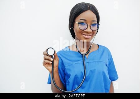 Ritratto di donna felice americano africano giovane medico pediatra in uniforme blu e il cappotto di uno stetoscopio isolato su bianco. Sanitario, medico, medic Foto Stock